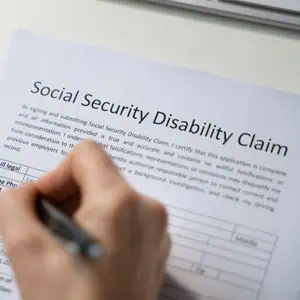 A person filling out a Social Security Disability Claim form symbolizing the North Carolina SSD claim - Lund Law Carolina 