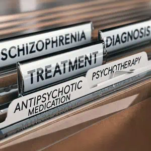 Close-up of medical files labeled with mental health-related terms like diagnosis, treatment, and medication